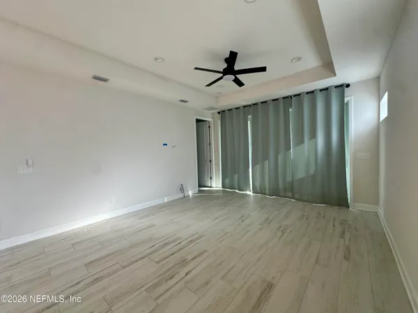 a view of empty room with wooden floor