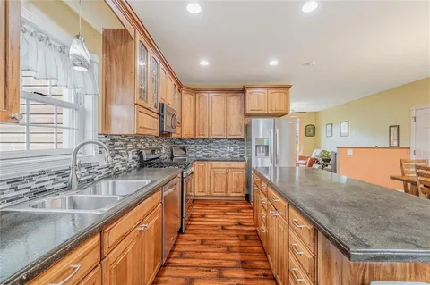 a large kitchen with stainless steel appliances granite countertop lots of counter space and a sink