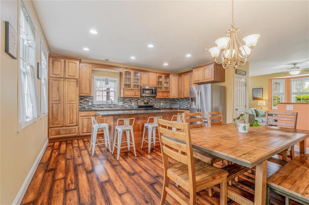 117 Hillcrest Road Renfrew, PA 16053 - Photo 10 of 30 a kitchen with stainless steel appliances granite countertop a stove a refrigerator a sink a dining table and chairs with wooden floor