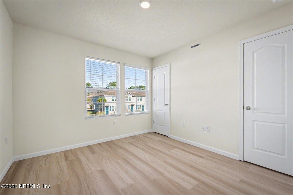 8212 Larose Road Jacksonville, FL 32211 - Photo 19 of 32 an empty room with wooden floor and windows