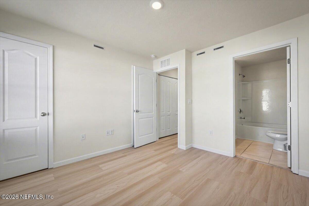 8212 Larose Road Jacksonville, FL 32211 - Photo 20 of 32 an empty room with wooden floor and mirror