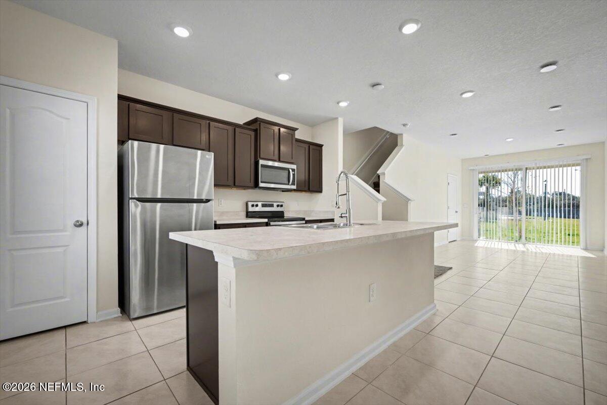 8212 Larose Road Jacksonville, FL 32211 - Photo 3 of 32 a kitchen with stainless steel appliances a refrigerator sink and cabinets