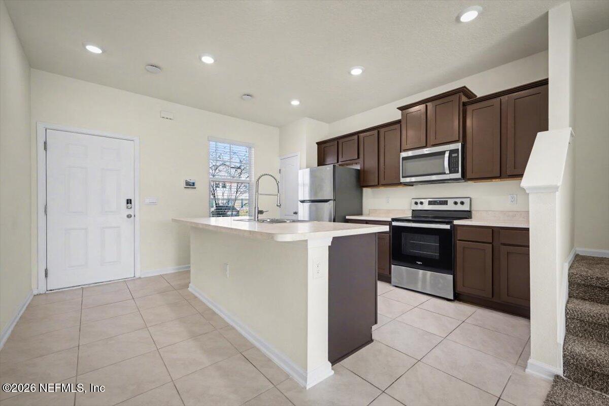 8212 Larose Road Jacksonville, FL 32211 - Photo 9 of 32 a kitchen with kitchen island granite countertop a stove sink and cabinets