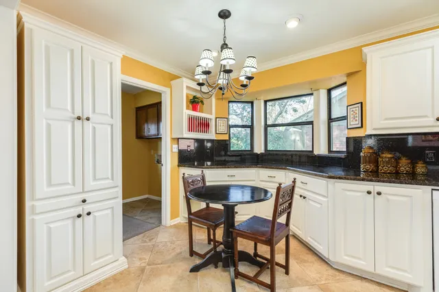 a kitchen with stainless steel appliances granite countertop a stove a sink and a refrigerator with white cabinets