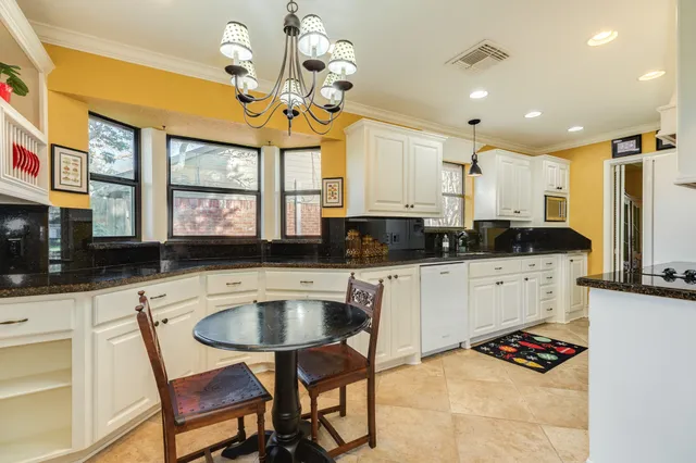 a kitchen with a stove a sink a dining table and chairs