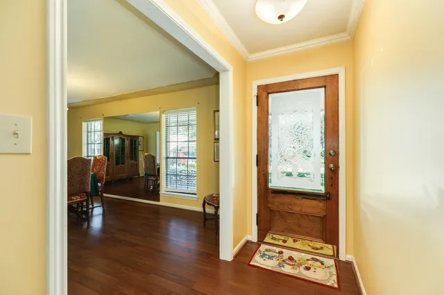a view of a hallway with wooden floor windows