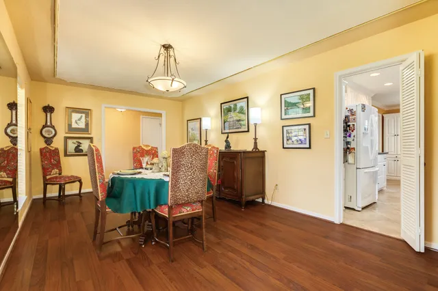 a view of a livingroom with furniture a chandelier and wooden floor