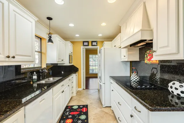 a large kitchen with stainless steel appliances granite countertop a sink stove and refrigerator
