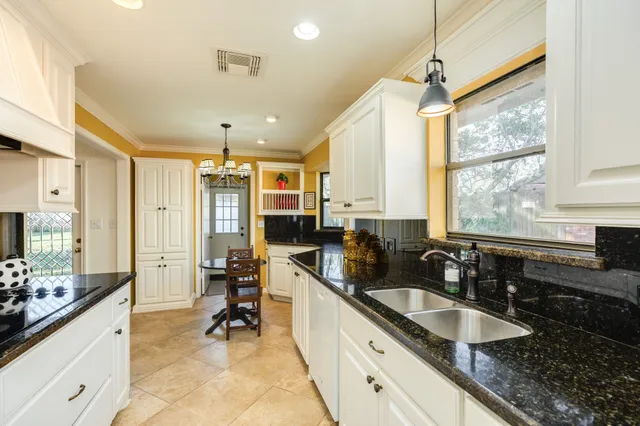 a large kitchen with kitchen island granite countertop a sink and cabinets
