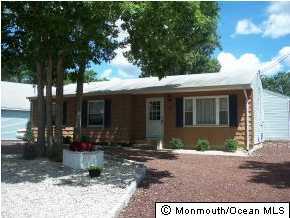 209 Clipper Road Manahawkin, NJ 08050 - Photo 1 of 3 a front view of a house with garden and patio