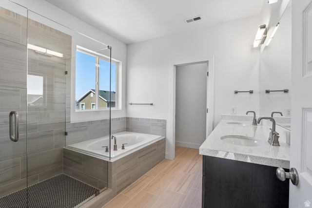 36 South Crimson Way, Unit 305 Mapleton, UT 84664 - Photo 6 of 7 Spacious bathroom featuring a frameless glass shower enclosure with tiled walls and a dark tile floor, alongside a built-in soaking tub with coordinating tile surround