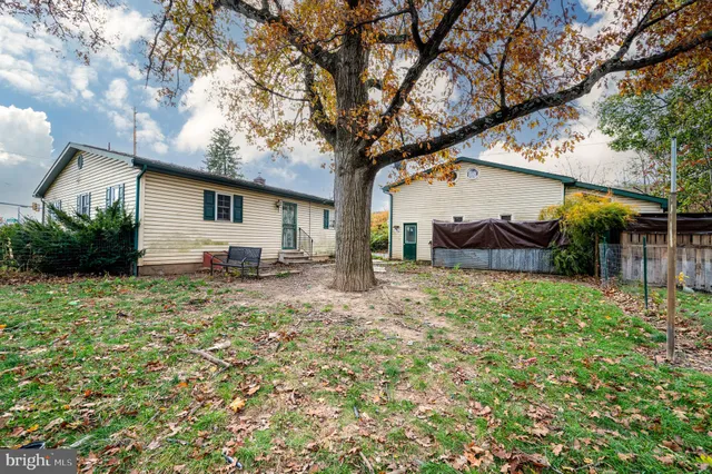 a white house that has a tree in front of it