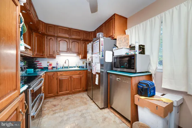 a kitchen with stainless steel appliances granite countertop a refrigerator and stove top oven