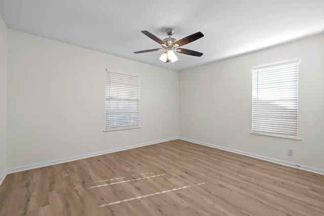 a view of an empty room with wooden floor