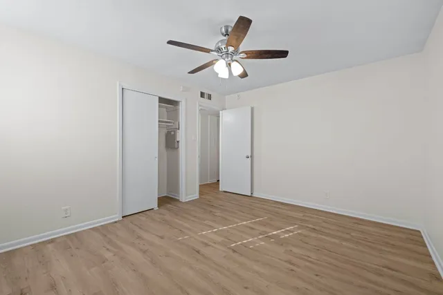 an empty room with wooden floor and windows