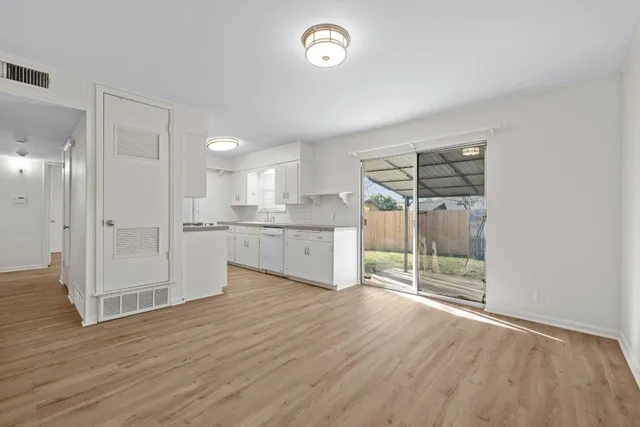 a view of a kitchen with wooden floor and a window