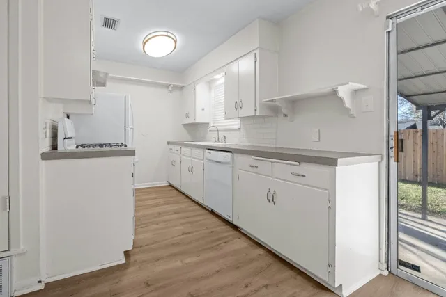 a kitchen with a sink cabinets stainless steel appliances and a window