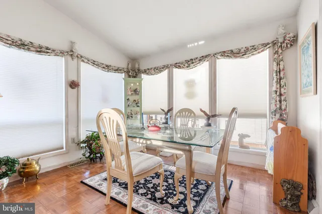 a dining room with wooden floor and a chandelier