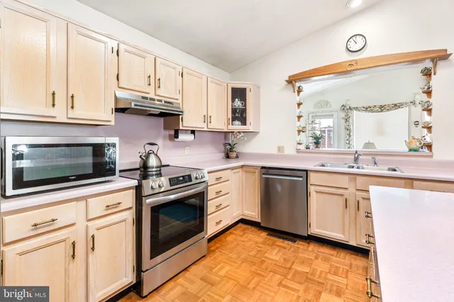 a kitchen with granite countertop white cabinets stainless steel appliances and a window
