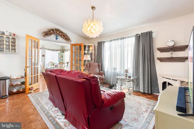 a living room with furniture a large window and a chandelier