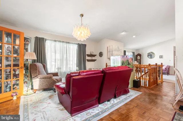 a living room with furniture a chandelier and a dining table