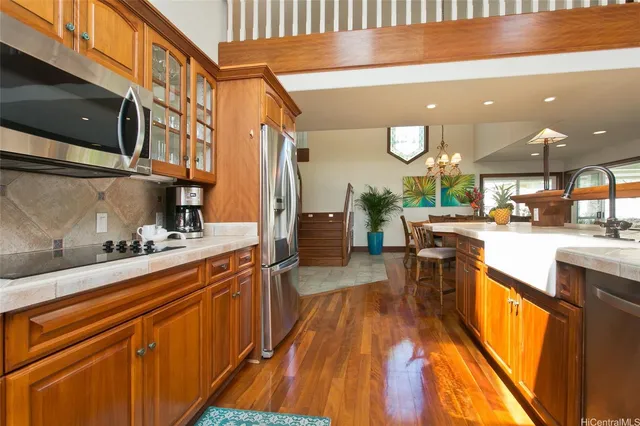a kitchen with stainless steel appliances granite countertop a sink a stove and a wooden floors