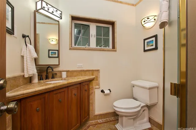 a bathroom with a toilet sink vanity and mirror