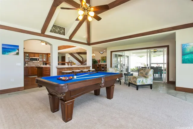 a room with pool table and glass windows