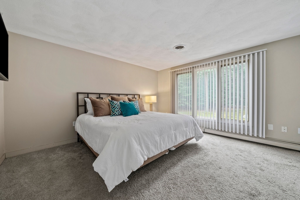 31 Dedham Street Sharon, MA 02067 - Photo 24 of 42 a bed sitting in a spacious bedroom next to a window