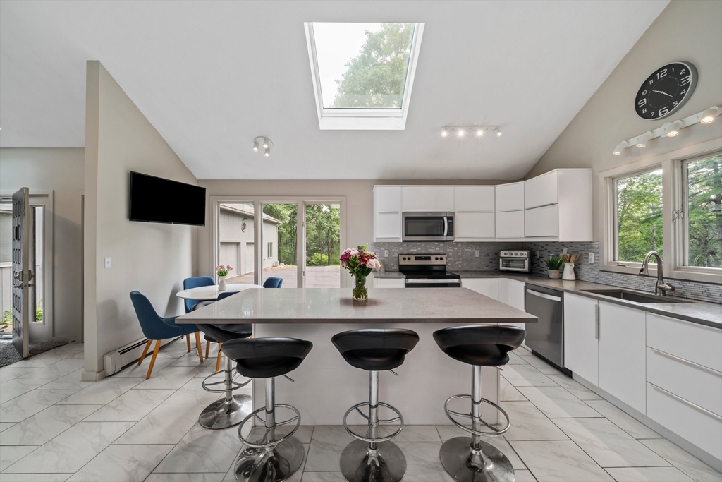 31 Dedham Street Sharon, MA 02067 - Photo 7 of 42 a kitchen with stainless steel appliances kitchen island granite countertop a dining table chairs and white cabinets