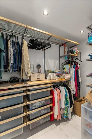 a view of walk in closet with clothes and shoes