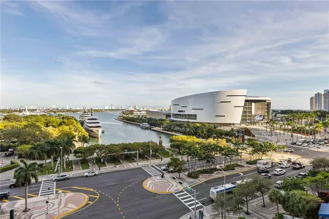 a dining room with furniture large windows and a rug