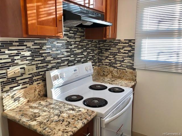 a kitchen stove top oven and cabinets