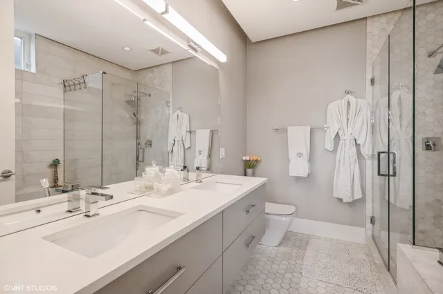 a bathroom with a double vanity sink mirror and toilet
