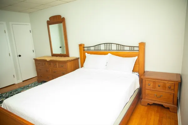 a bedroom with a bed and wooden floor