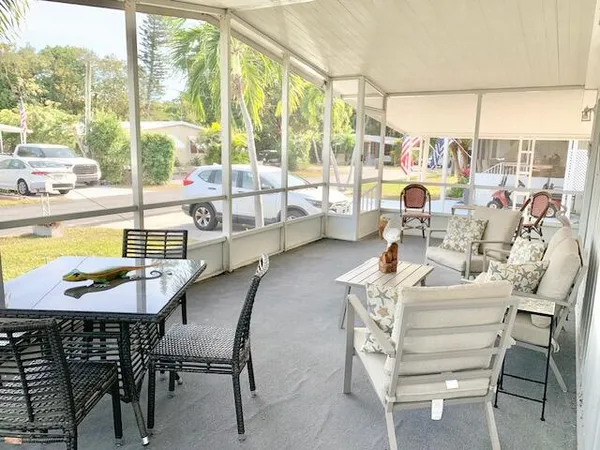 a dining room with furniture and a floor to ceiling window