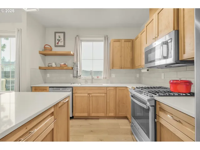 a kitchen with stainless steel appliances granite countertop a sink dishwasher and cabinets with wooden floor