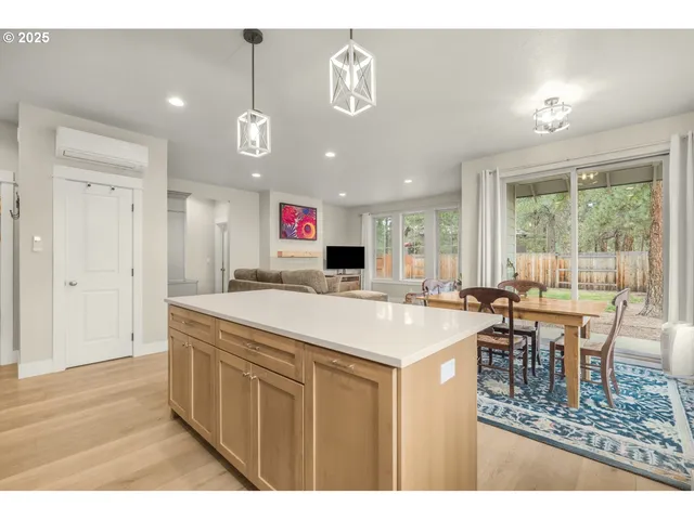 a dining hall with stainless steel appliances kitchen island granite countertop a dining table and chairs