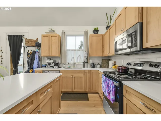 a kitchen with kitchen island a counter top space a sink a stove and a refrigerator