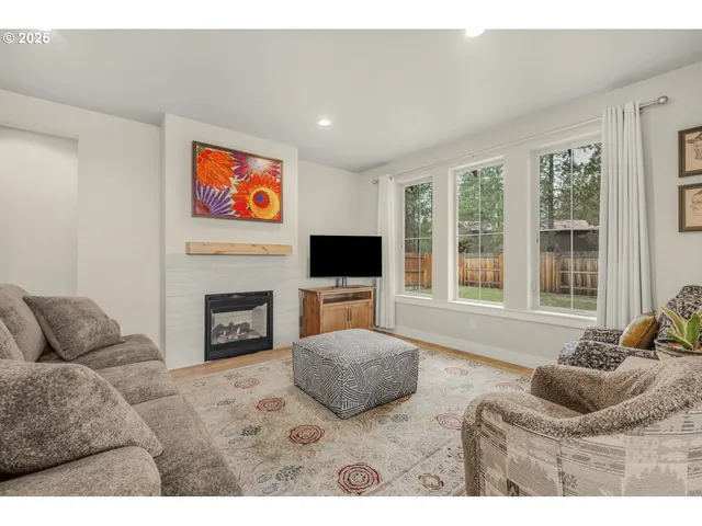 a living room with furniture a flat screen tv and a fireplace