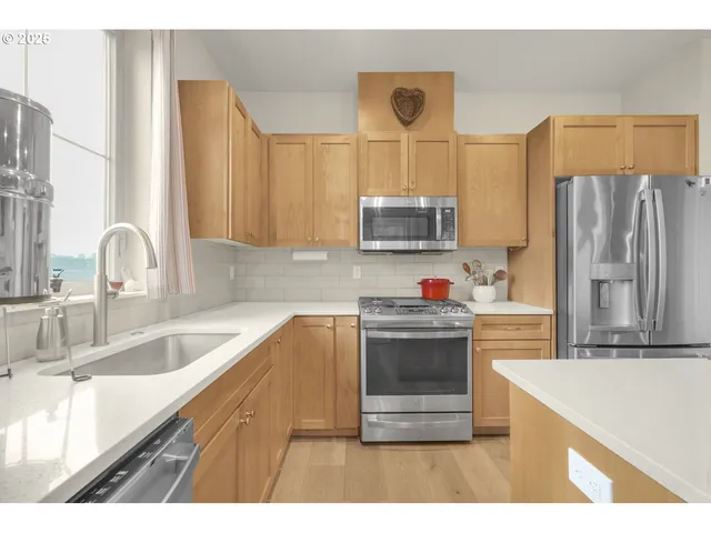 a kitchen with kitchen island granite countertop a sink stove and refrigerator