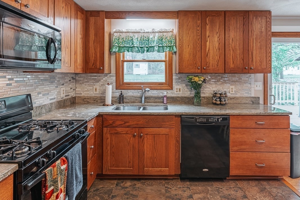 26 Hunter Avenue Hudson, MA 01749 - Photo 11 of 42 a kitchen with granite countertop stainless steel appliances a stove sink and cabinets