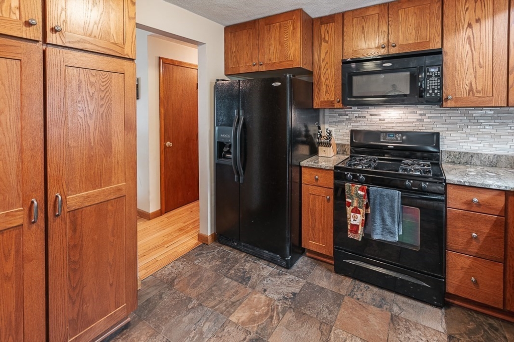 26 Hunter Avenue Hudson, MA 01749 - Photo 13 of 42 a kitchen with granite countertop a refrigerator stove and microwave