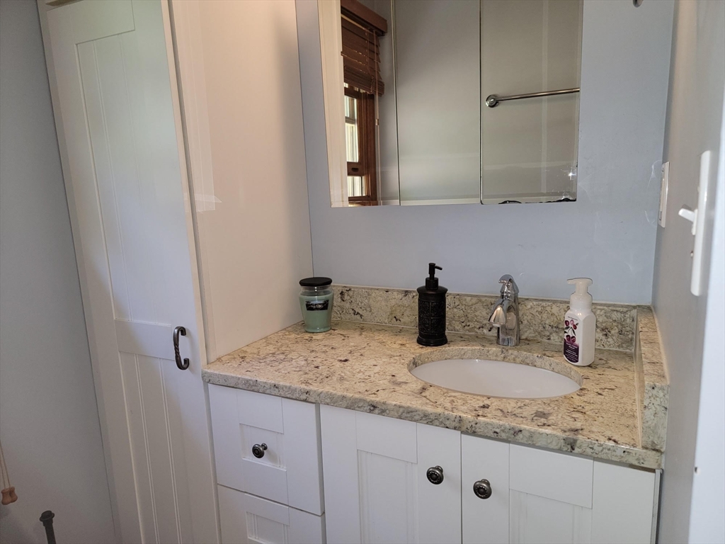 26 Hunter Avenue Hudson, MA 01749 - Photo 16 of 42 a bathroom with a granite countertop sink and a mirror