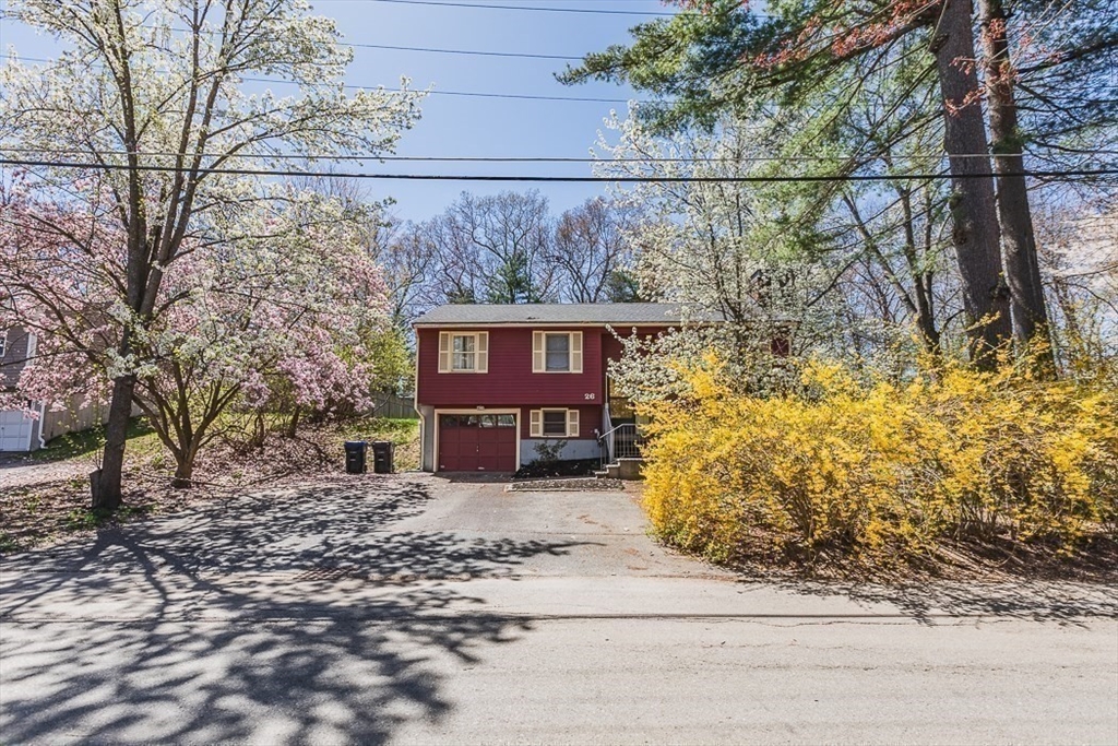26 Hunter Avenue Hudson, MA 01749 - Photo 42 of 42 a view of a brick house next to a yard with large trees