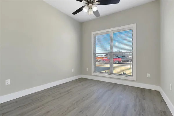en empty room with windows and ceiling fan