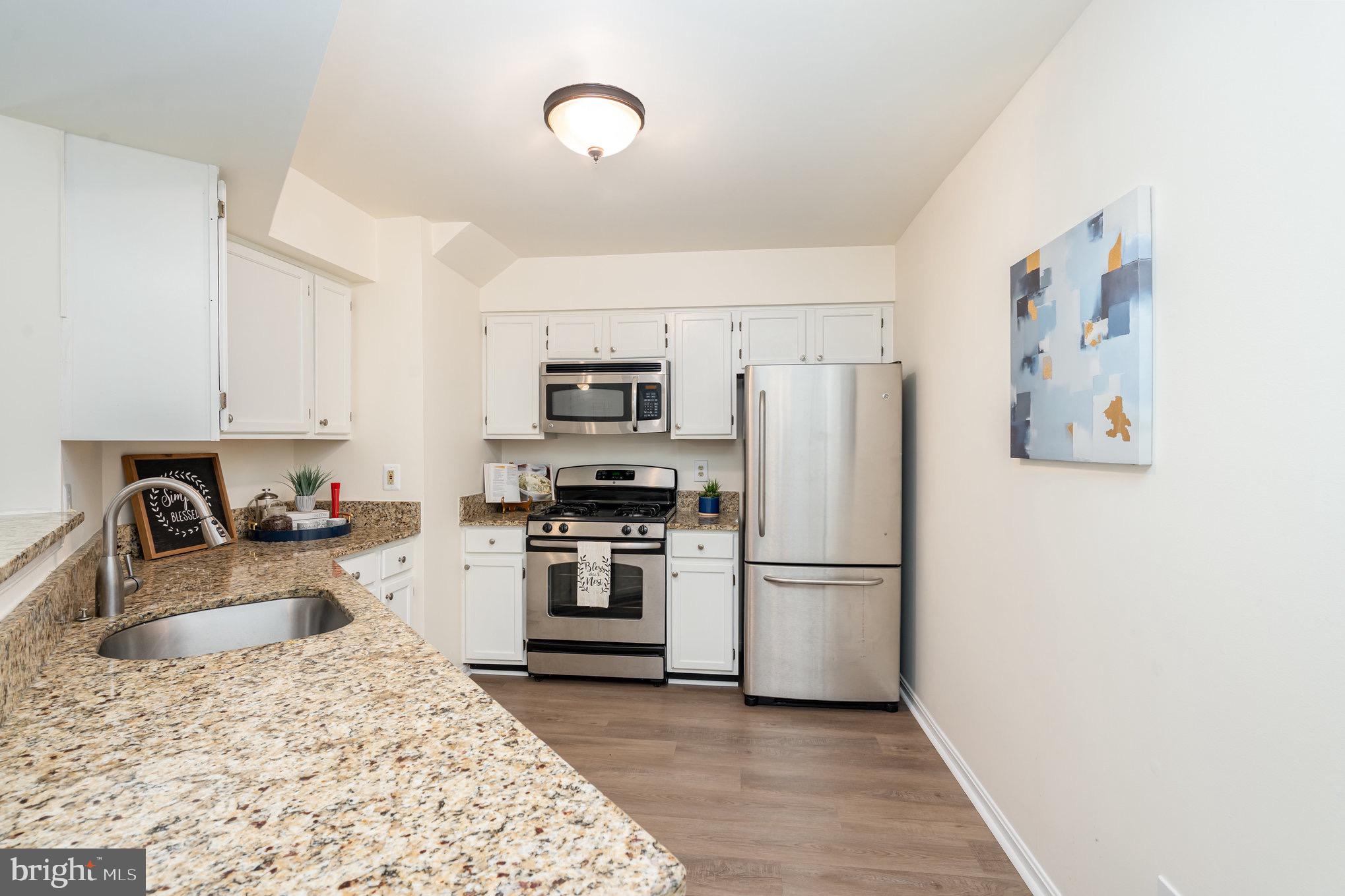 4068 Chetham Way Woodbridge, VA 22192 - Photo 12 of 27 a kitchen with wooden cabinets and stainless steel appliances