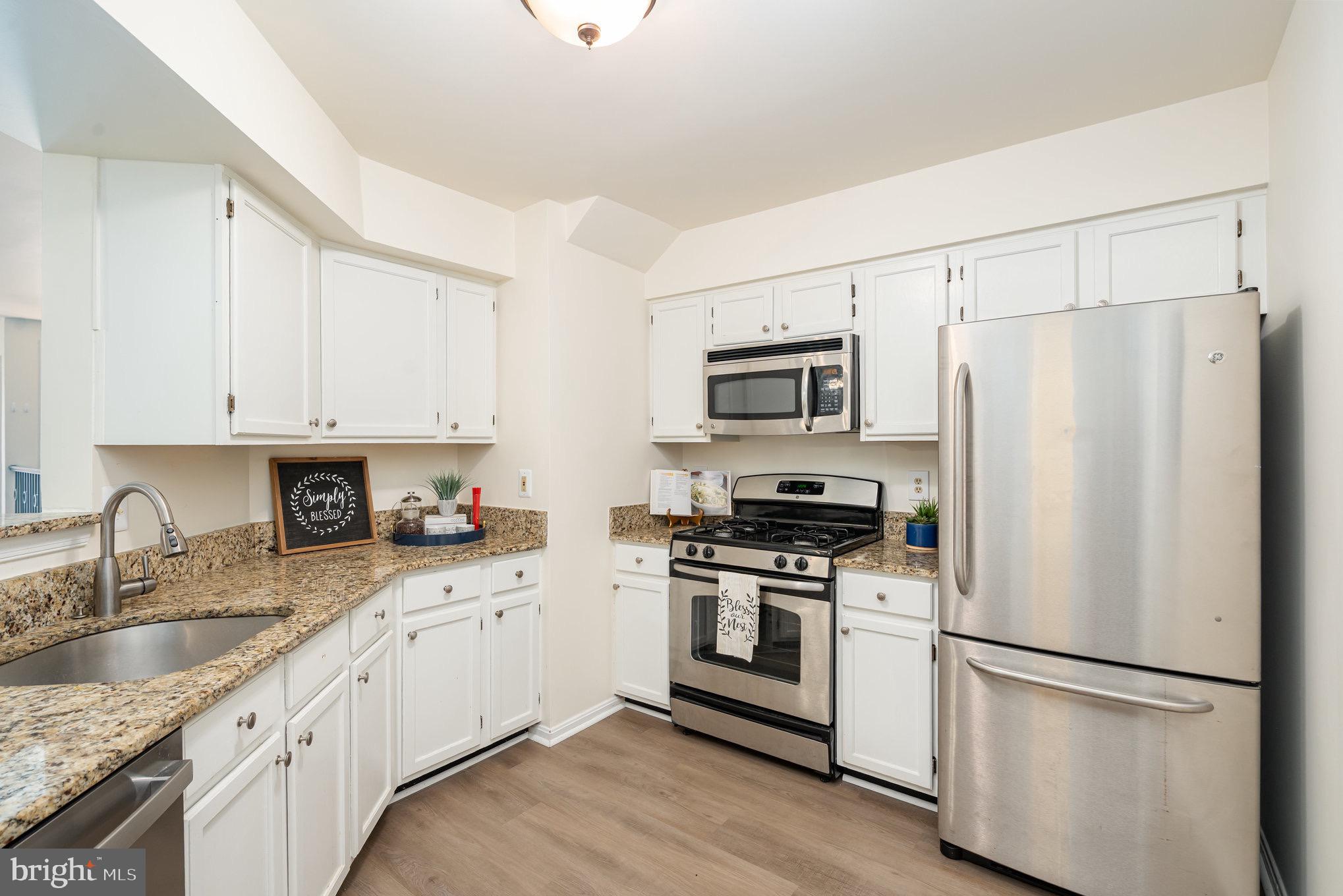 4068 Chetham Way Woodbridge, VA 22192 - Photo 13 of 27 a kitchen with granite countertop white cabinets and white appliances