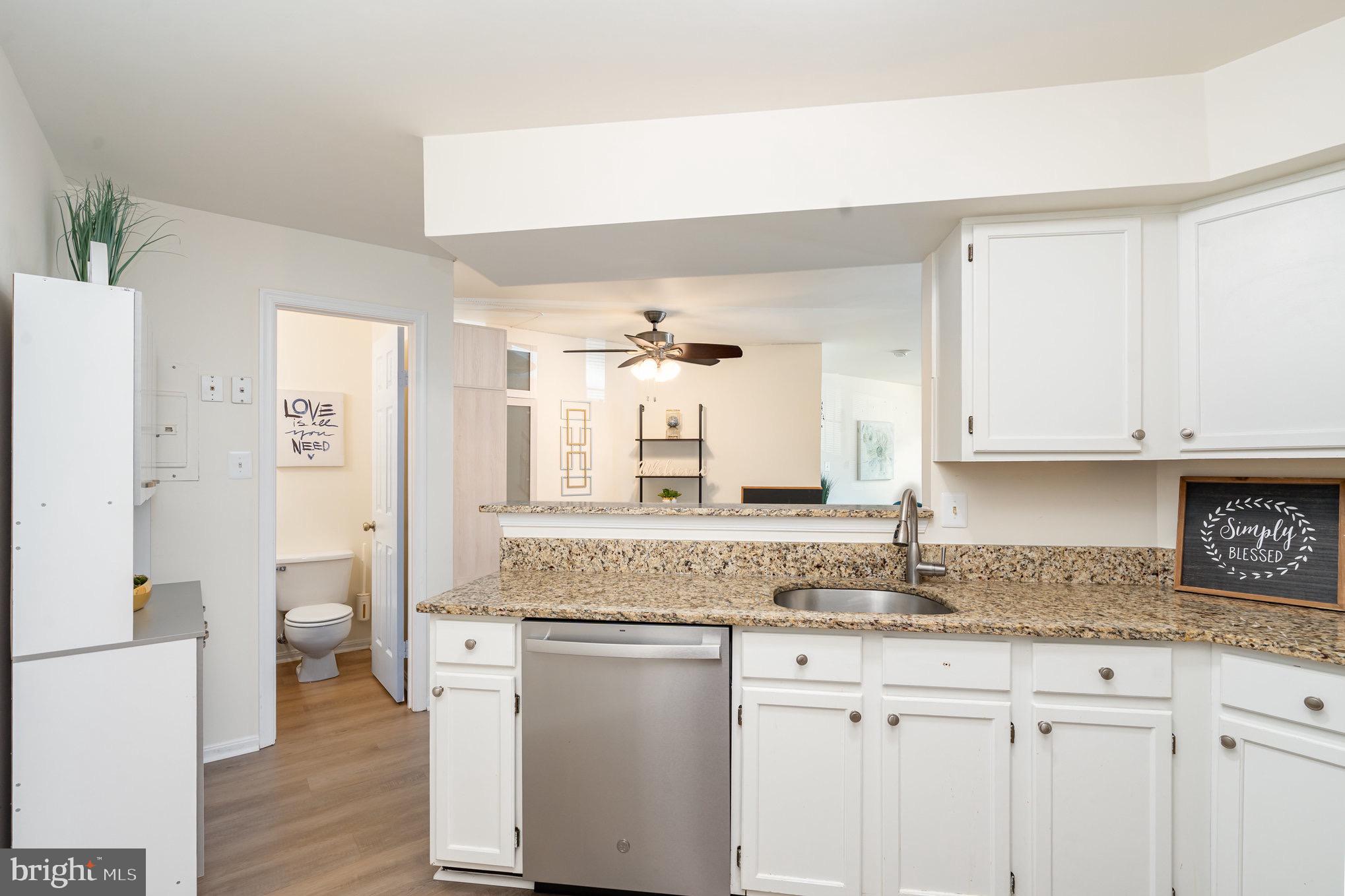 4068 Chetham Way Woodbridge, VA 22192 - Photo 14 of 27 a kitchen with granite countertop a sink and cabinets with wooden floor