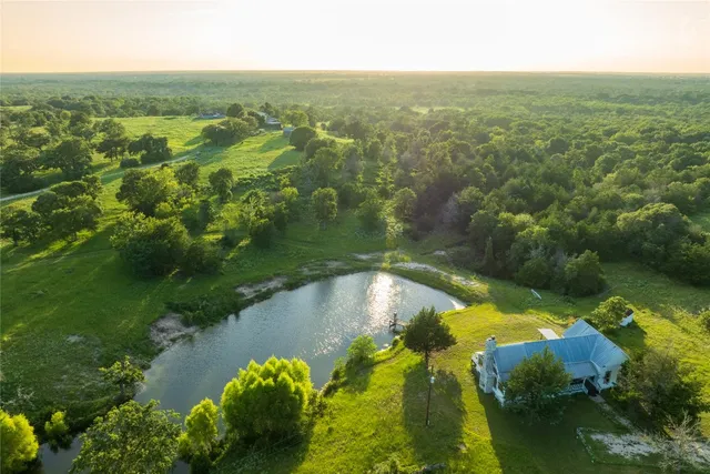 an aerial view of lake residential house with outdoor space and trees around